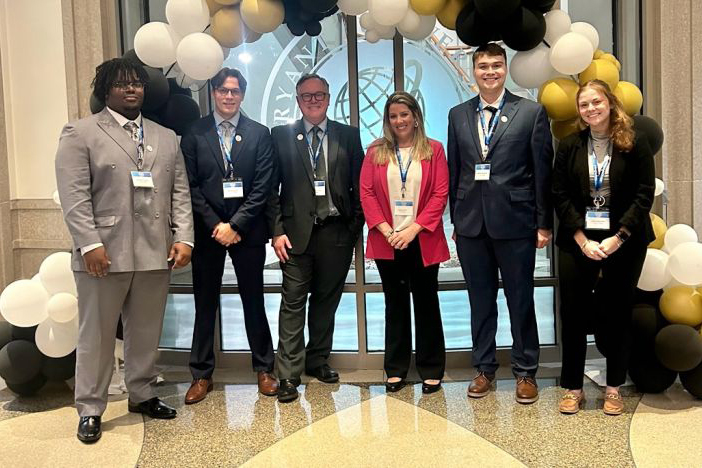 students post at sales competition lobby at bryant university