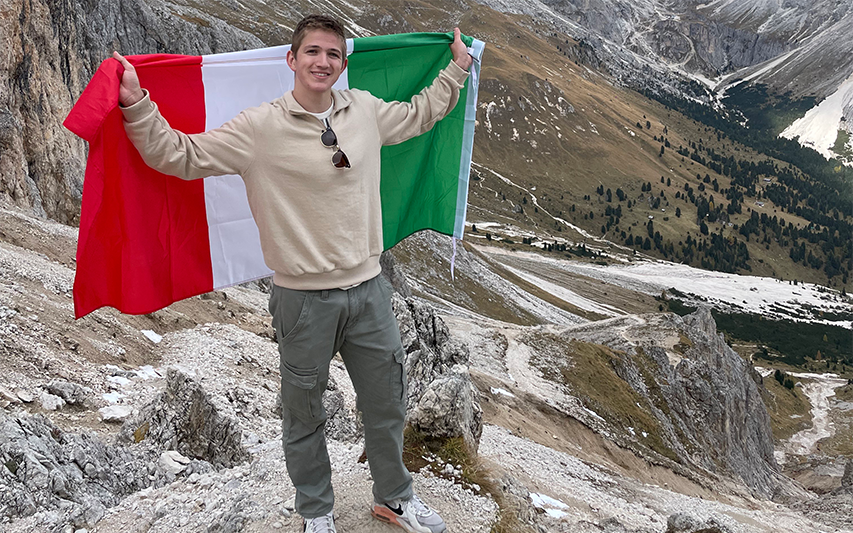 Joey Deprey poses with Italian flag while in mountains of Italy