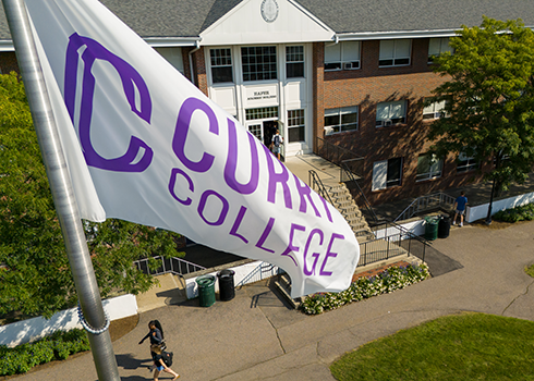 Curry College flag flies on the Academic Quad