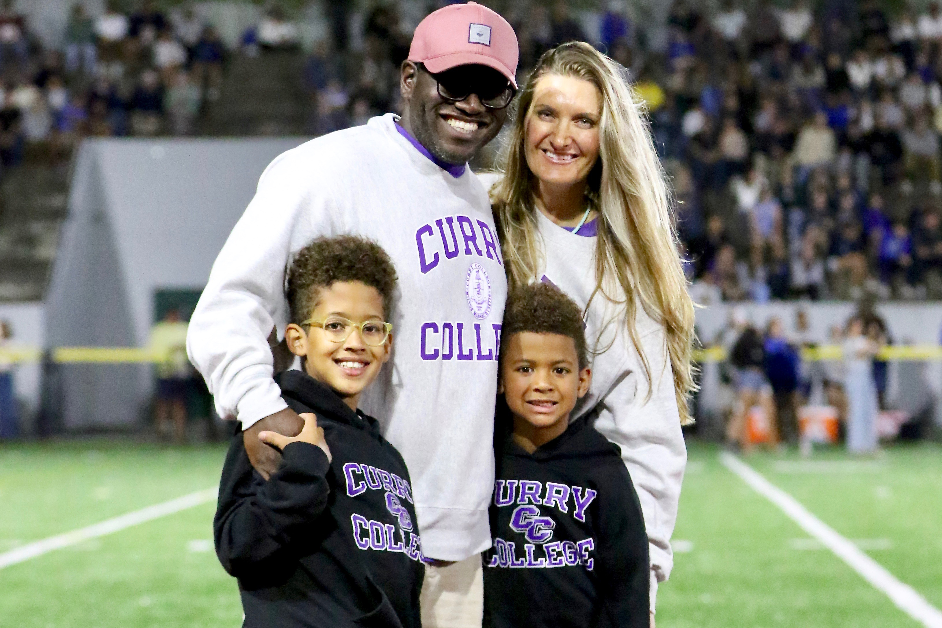 roby, bo, and family pose on football field in curry gear