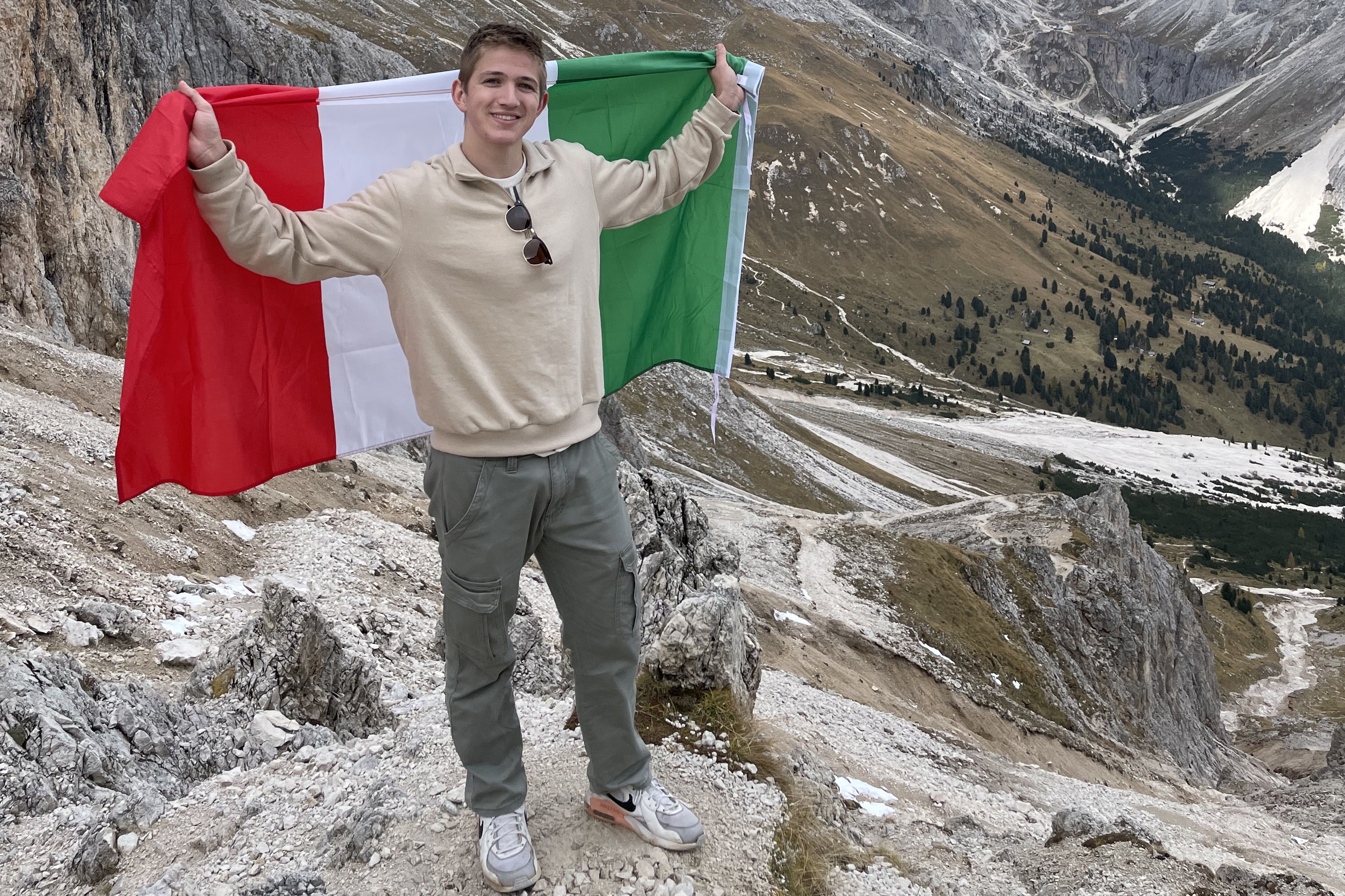 Joey Deprey poses with Italian flag while in mountains of Italy