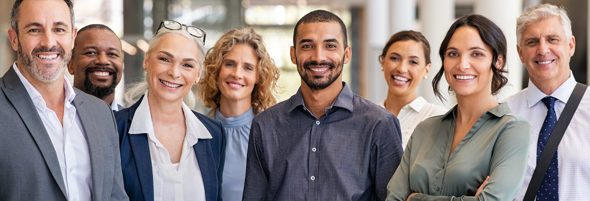 A diverse group of teachers smile for a photo