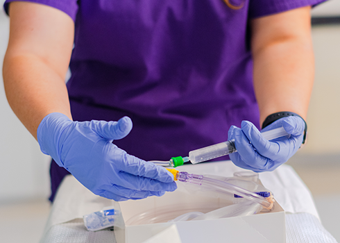 A Curry nurse prepares a syringe in the SIM Lab