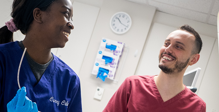 A nursing professor teaches a student in the simulation lab