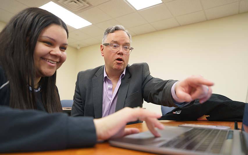 Dr. Shawn Scott, Marketing Professor at Curry College, works with a student in the classroom