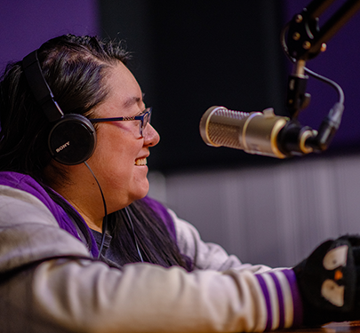 A student on air at the WMLN podcast studio, Curry College's radio station