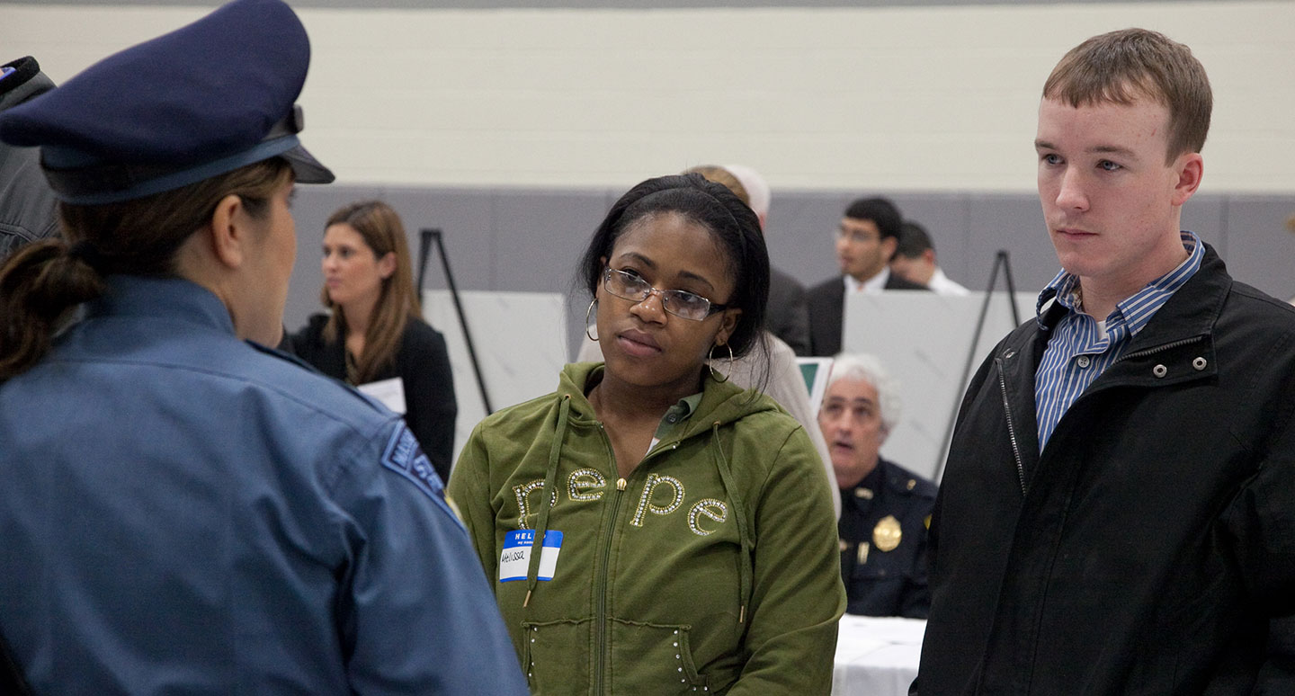 Students listen to a police officer give career advice