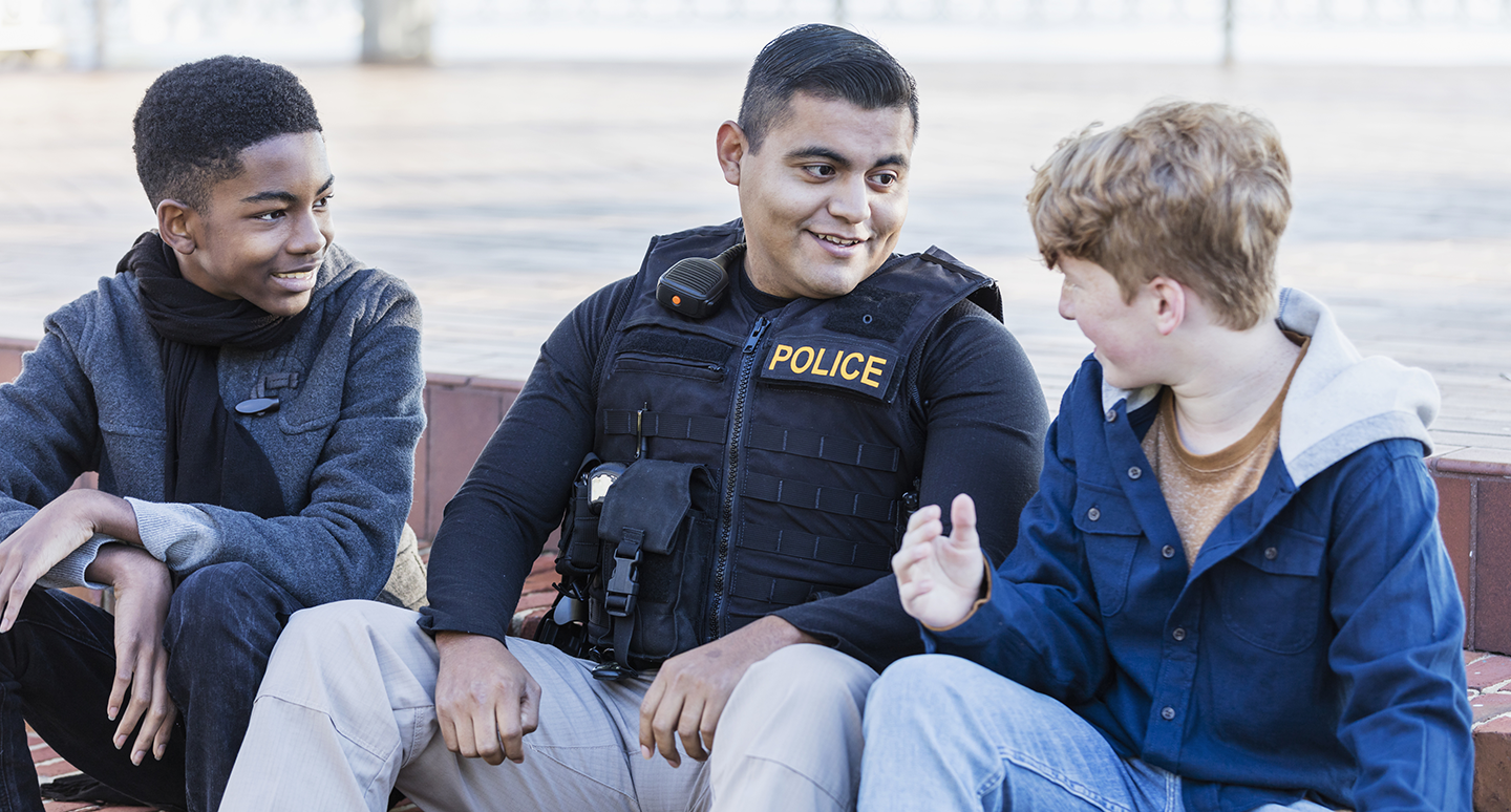 Law enforcement agent speaks with community children