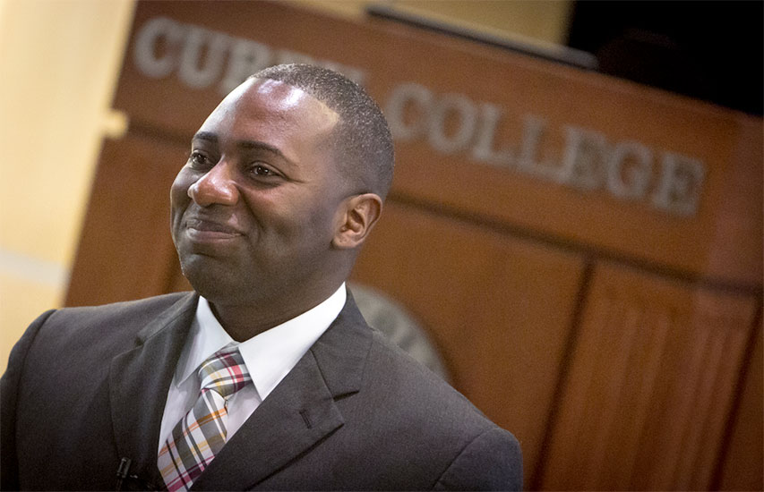 A Curry College Master of Arts in Criminal Justice degree student smiles at graduation