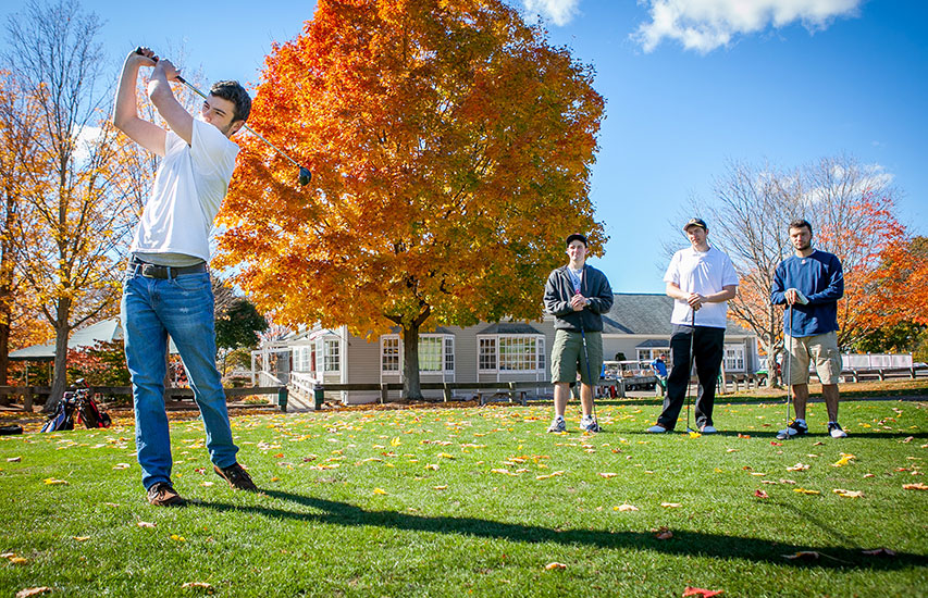 Curry College students on the golf course as part of the Physical Education program