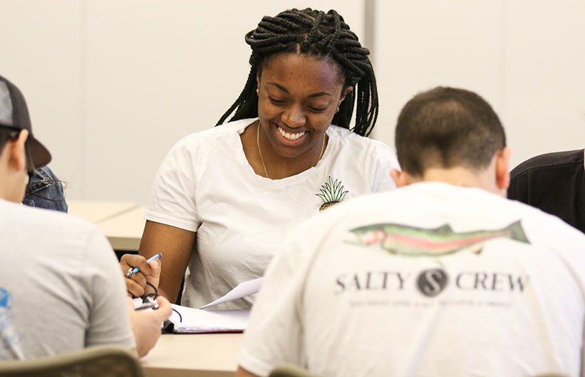 Student smiling in class at Curry College pursuing an Individually Initiated Major Degree at Curry College