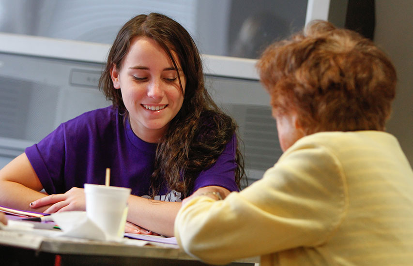 Curry College student interacting with a local senior, representing the Curry College Gerontology minor and concentration