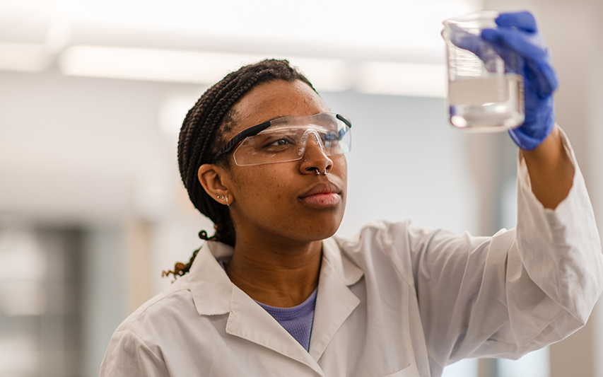 Curry College student performs an experiment in the Science and Research Center