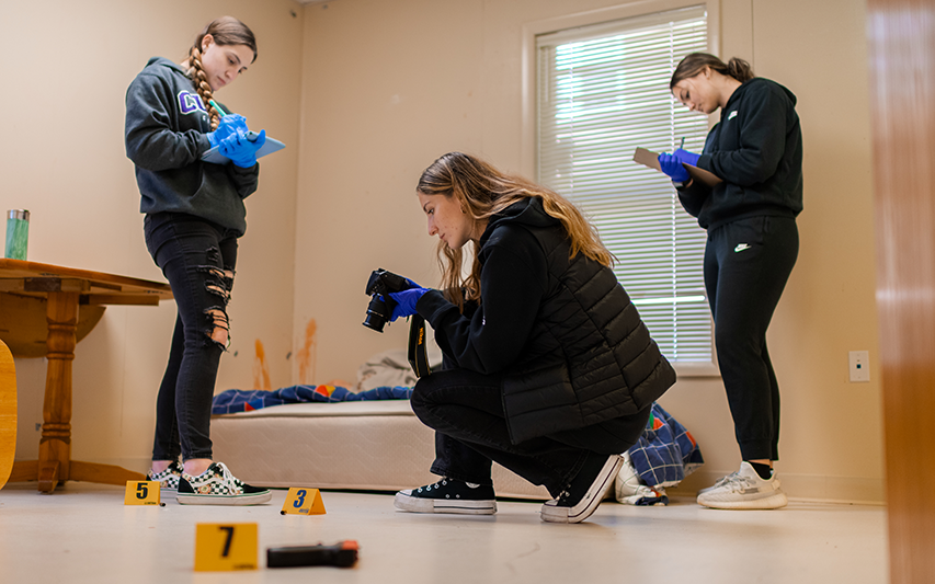 Students analyze a crime scene in the Forensic Science Lab and Training Center at Curry College