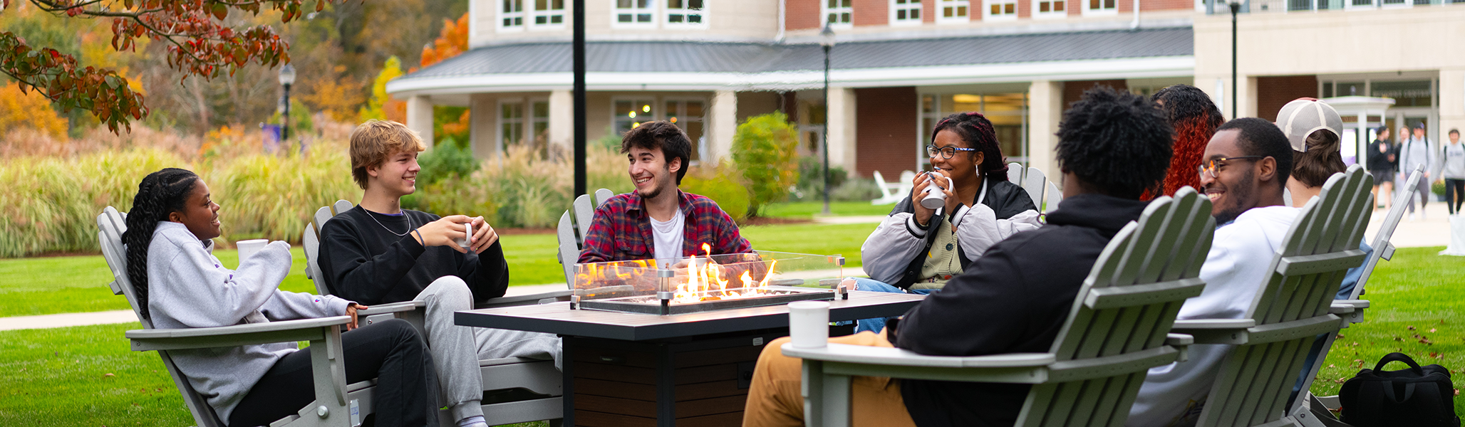 Students hang out around the firepit at Curry College