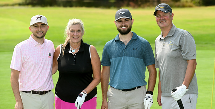 A Curry College Classic foursome pose for a photo