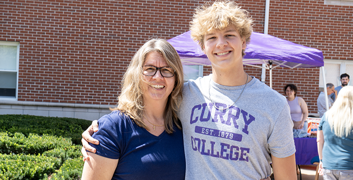 A student poses for a picture with his mother at move-in day