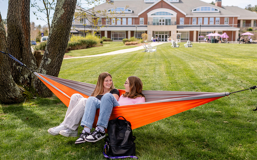 Students hang out on a hammock at Curry College's Westhaver Park
