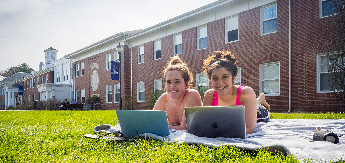 Students laying on the grass on the Curry College campus